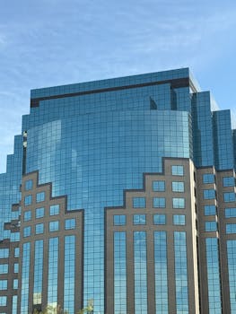 Captivating architecture of a modern blue glass skyscraper reflecting the clear sky.
